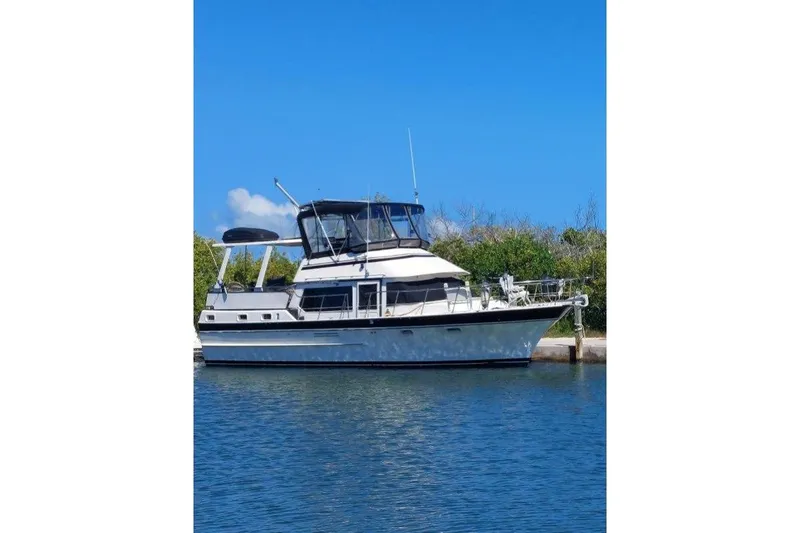 The Image of 1984 Kha Shing 40 Spindrift yacht docked on calm water under clear blue sky. - 0