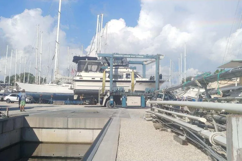 Slide: The Image of 1984 Kha Shing 40 Spindrift yacht on dry dock, surrounded by other boats. - 2