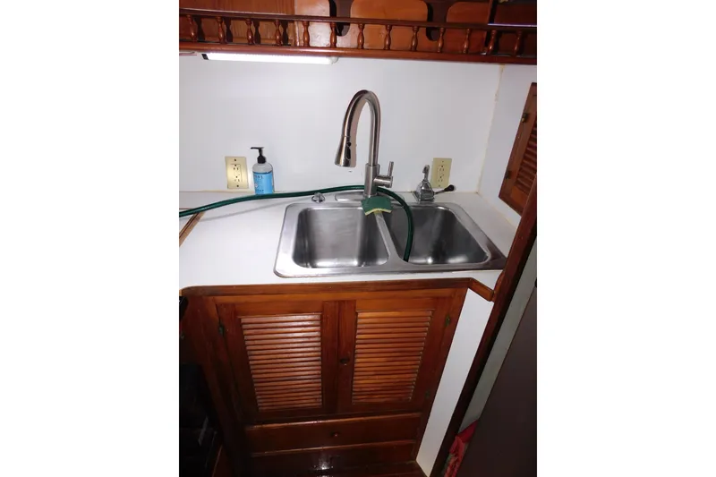 Slide: The Image of 1984 Kha Shing 40 Spindrift yacht kitchen sink with wooden cabinetry and dual basins. - 31