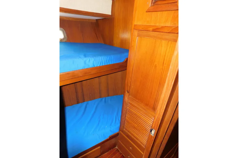 Slide: The Image of Interior of 1984 Kha Shing 40 Spindrift yacht with wooden bunk beds and blue bedding. - 41