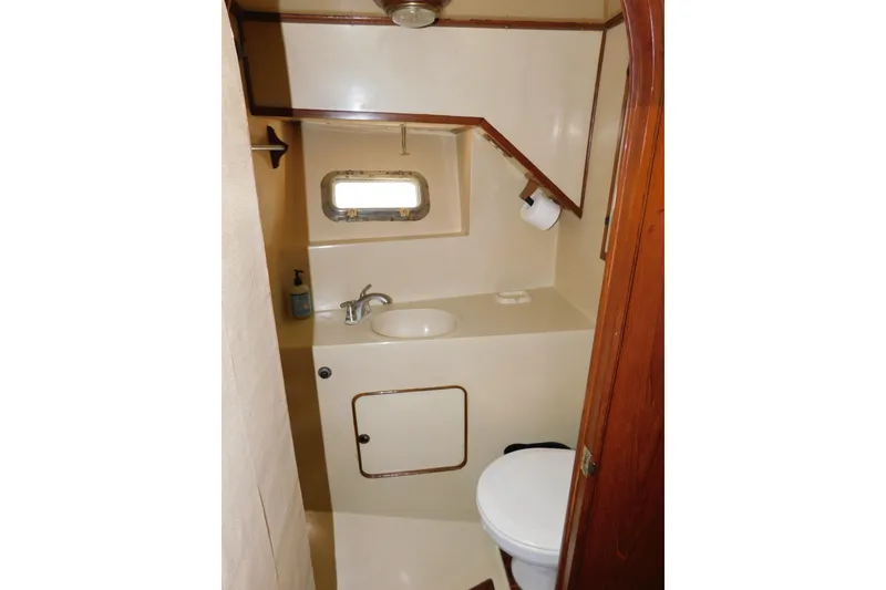 Slide: The Image of 1984 Kha Shing 40 Spindrift yacht bathroom with sink, toilet, and porthole window. - 44
