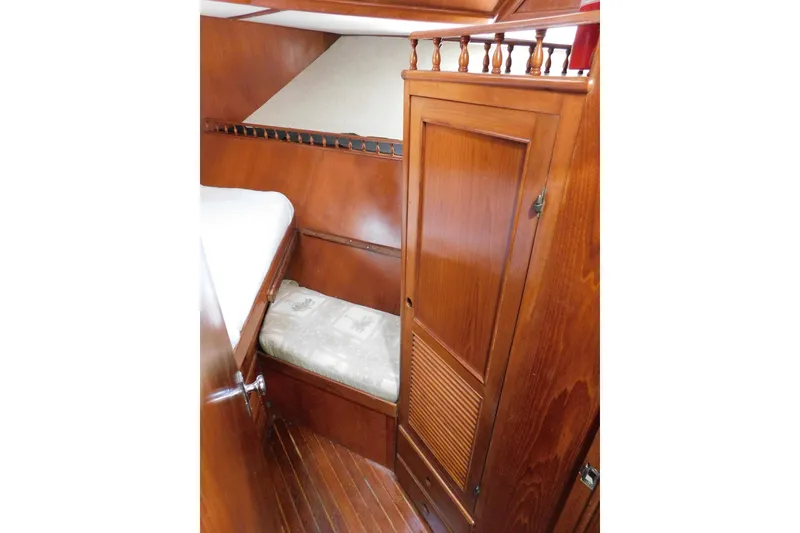 Slide: The Image of 1984 Kha Shing 40 Spindrift cabin interior with wooden cabinetry and cozy sleeping area. - 47