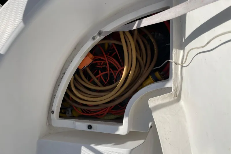 Slide: The Image of Storage compartment on a 1999 Hunter 460 boat with hoses and equipment. - 17