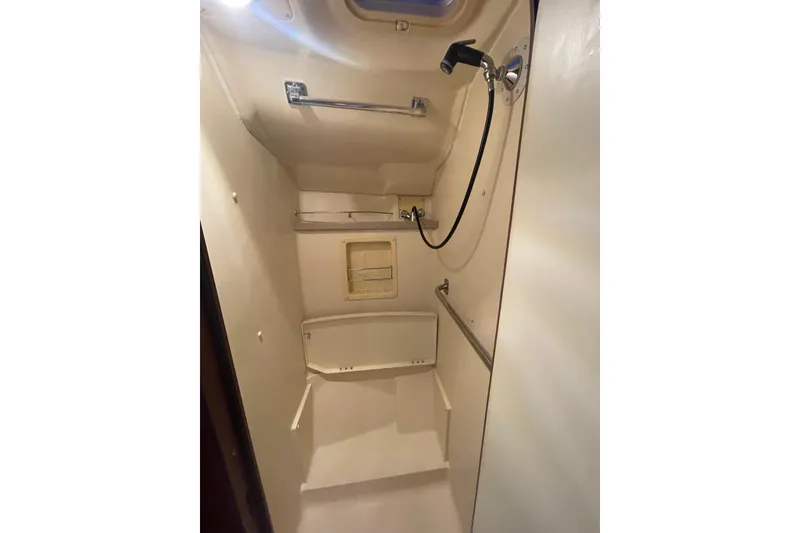 Slide: The Image of Compact shower area in a 1999 Hunter 460 sailboat, featuring a handheld showerhead. - 46