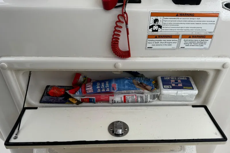 Slide: The Image of 2019 Sea Chaser 24 HFC storage compartment with safety gear and first aid kit. - 12