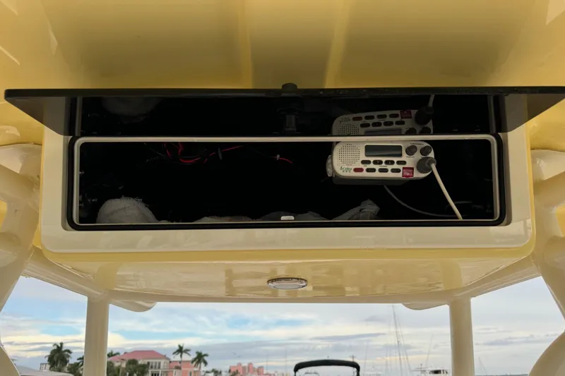 Slide: The Image of 2019 Sea Chaser 24 HFC boat console with radio equipment and open storage compartment. - 13