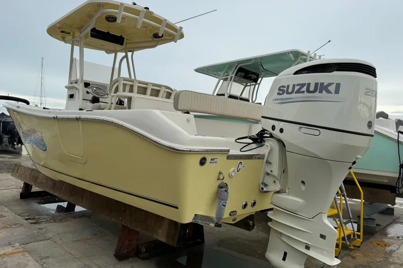 Slide: The Image of 2019 Sea Chaser 24 HFC boat with Suzuki outboard motor, docked on a platform. - 23