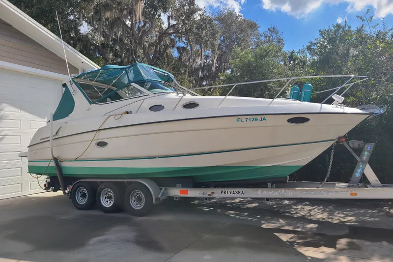 The Image of 1996 Regal Commodore 292 boat on trailer, parked outdoors near garage. - 0