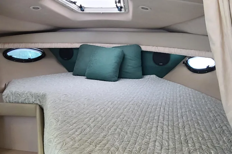 Slide: The Image of Cozy cabin interior of 1996 Regal Commodore 292 with quilted bedding and porthole windows. - 12
