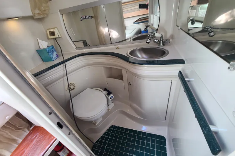 Slide: The Image of Compact bathroom in a 1996 Regal Commodore 292 boat, featuring a toilet and sink. - 13