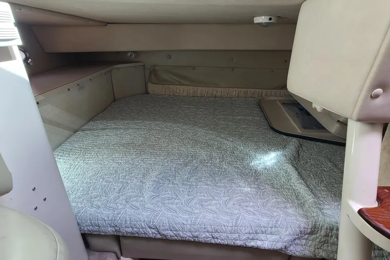 Slide: The Image of 1996 Regal Commodore 292 cabin interior with a cozy bed and soft lighting. - 16