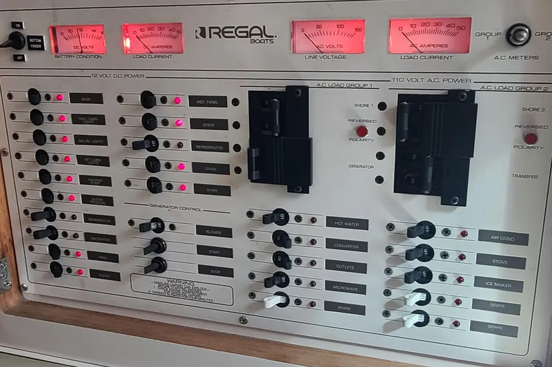 Slide: The Image of Control panel of a 1996 Regal Commodore 292 boat, featuring various switches and meters. - 17