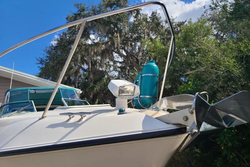 Slide: The Image of 1996 Regal Commodore 292 boat with anchor and lush greenery background. - 4