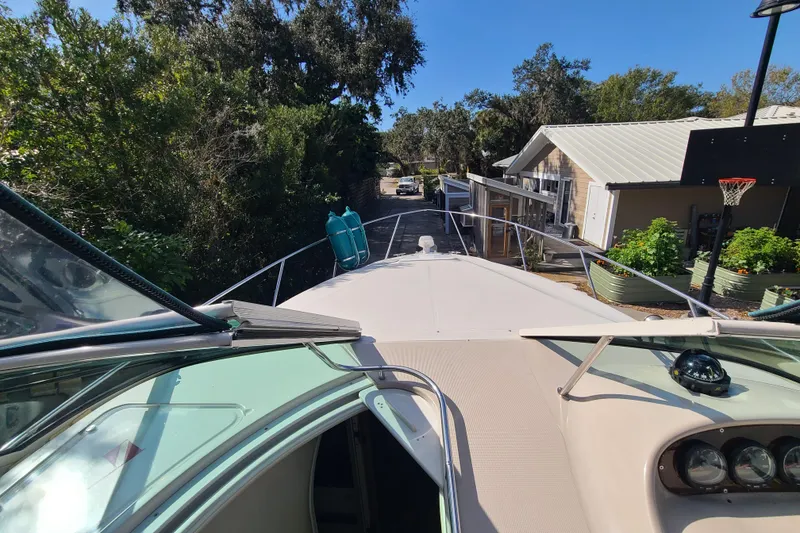 Slide: The Image of 1996 Regal Commodore 292 boat docked near residential area with lush greenery. - 5