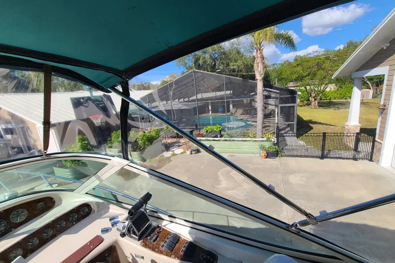 Slide: The Image of 1996 Regal Commodore 292 boat cockpit view, overlooking a backyard with a pool and palm tree. - 8
