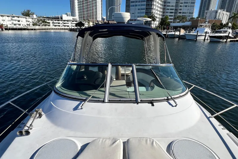 Slide: The Image of 2006 Four Winns 348 Vista boat docked in a marina with city skyline. - 100