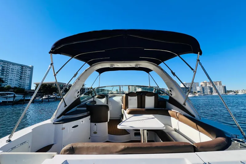 Slide: The Image of 2006 Four Winns 348 Vista boat interior with seating, table, and canopy on a sunny day. - 111