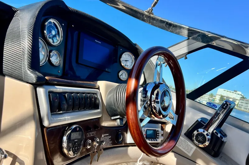 Slide: The Image of 2006 Four Winns 348 Vista boat dashboard with steering wheel and control panel. - 117