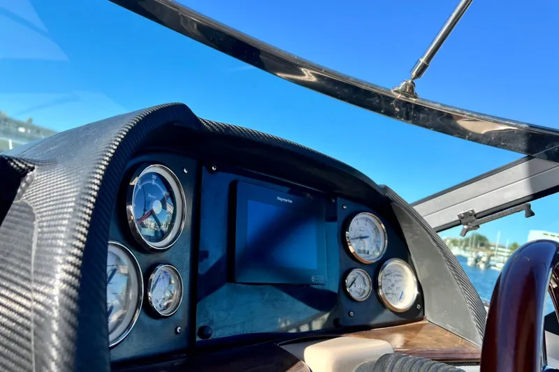 Slide: The Image of 2006 Four Winns 348 Vista dashboard with gauges and navigation screen under clear blue sky. - 118