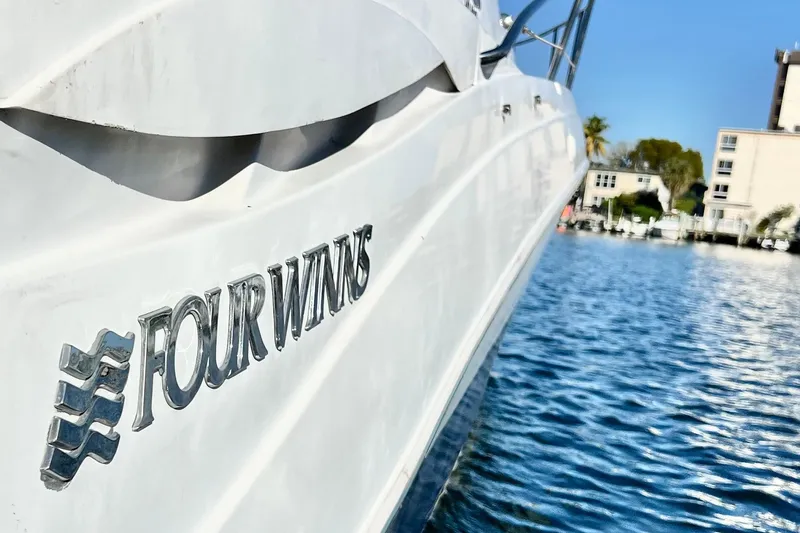 Slide: The Image of 2006 Four Winns 348 Vista boat on water, showcasing sleek design and branding. - 120