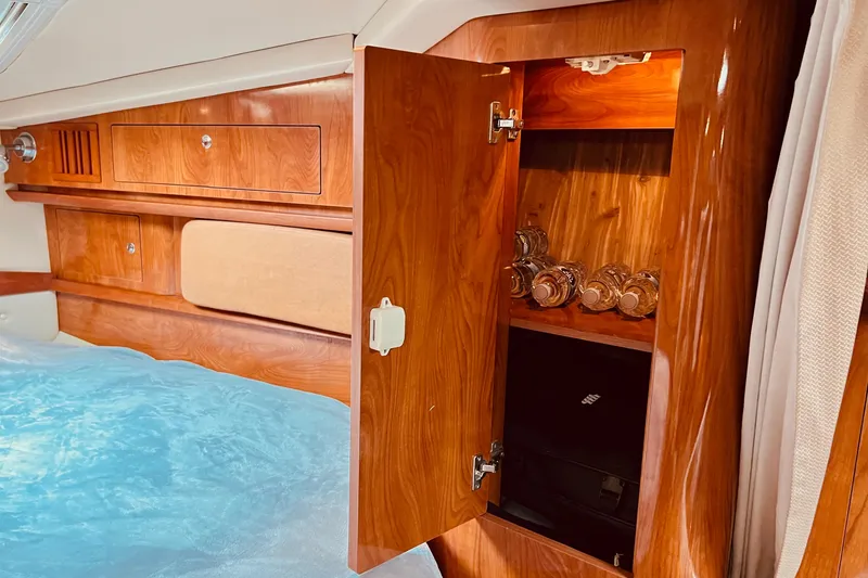 Slide: The Image of Luxurious wooden interior of 2006 Four Winns 348 Vista yacht cabin with open cabinet. - 31