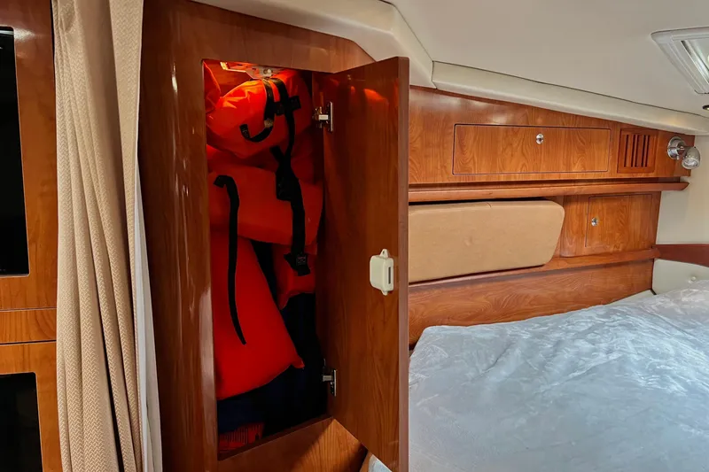 Slide: The Image of 2006 Four Winns 348 Vista cabin with life jackets in wooden storage. - 32