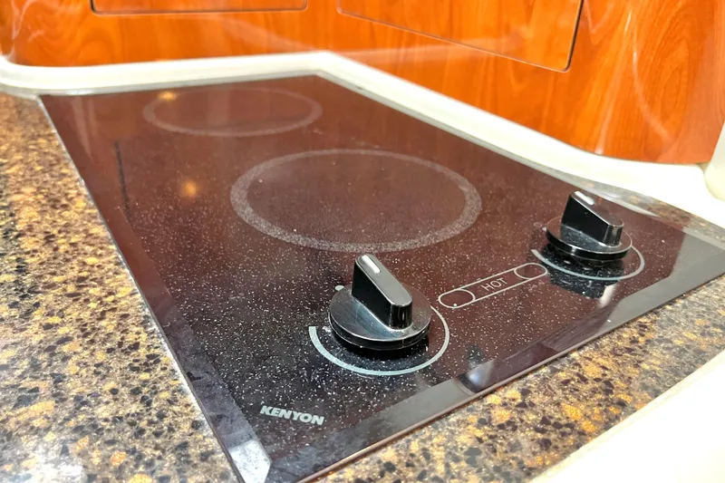 Slide: The Image of Kenyon stovetop in 2006 Four Winns 348 Vista boat kitchen, featuring sleek black design. - 34