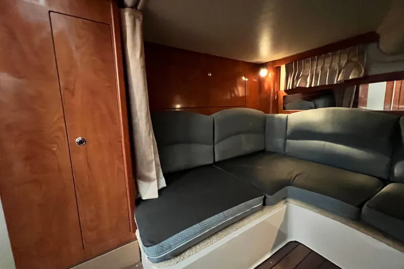 Slide: The Image of 2006 Four Winns 348 Vista cabin interior with plush seating and wooden cabinetry. - 38
