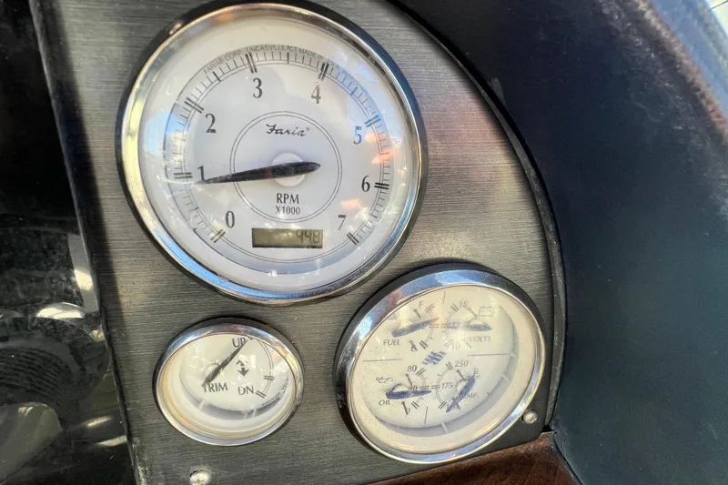 Slide: The Image of Dashboard gauges of a 2006 Four Winns 348 Vista boat, showing RPM, trim, and fuel levels. - 61