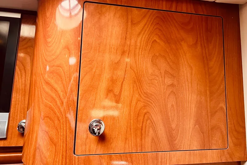 Slide: The Image of Wooden cabinet door with chrome handle inside a 2006 Four Winns 348 Vista boat. - 68