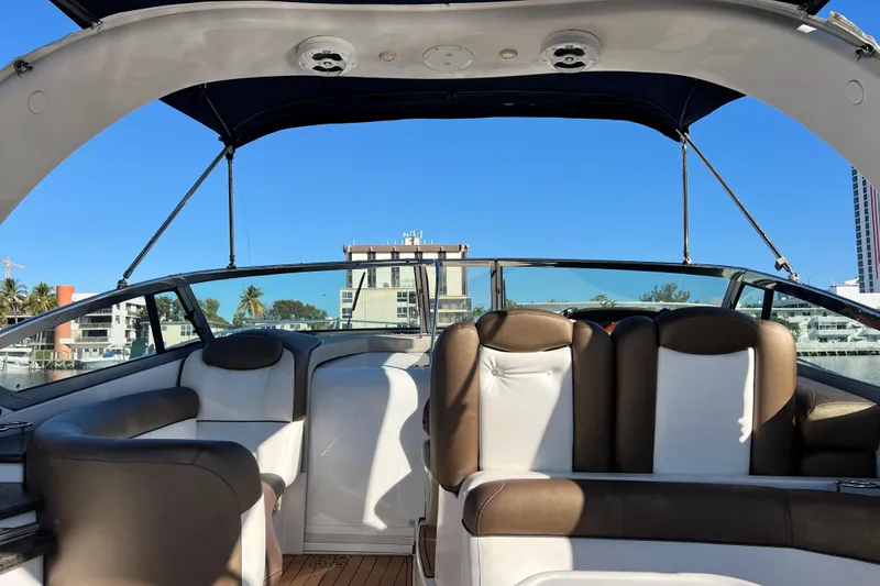Slide: The Image of 2006 Four Winns 348 Vista boat interior with brown and white seating, open canopy, and cityscape view. - 71