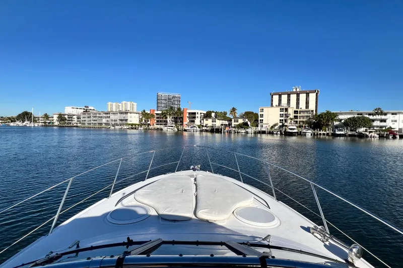 Slide: The Image of 2006 Four Winns 348 Vista yacht cruising near waterfront buildings under clear blue sky. - 86