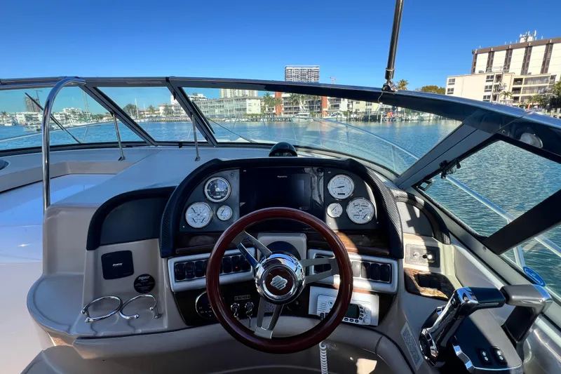 Slide: The Image of 2006 Four Winns 348 Vista yacht helm with gauges and steering wheel, overlooking marina. - 87
