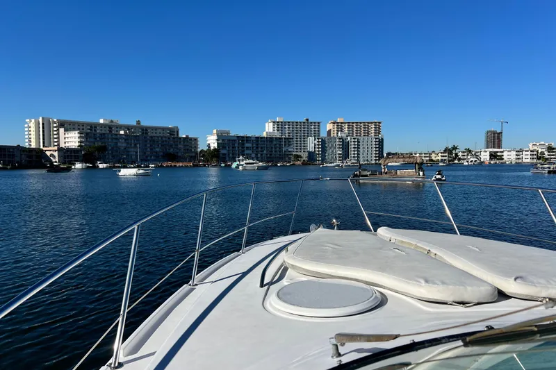 Slide: The Image of 2006 Four Winns 348 Vista yacht cruising near waterfront buildings under clear blue sky. - 91