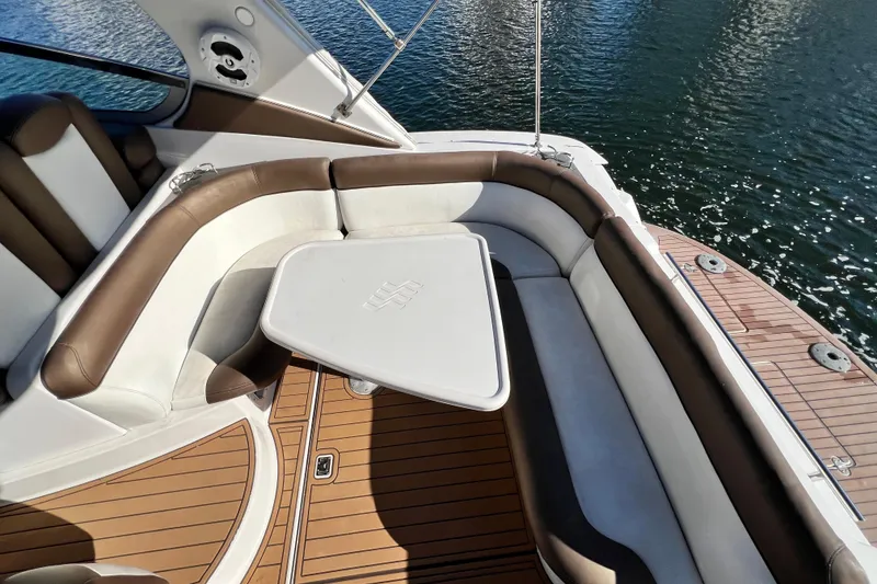 Slide: The Image of 2006 Four Winns 348 Vista boat interior with cushioned seating and table, overlooking water. - 97