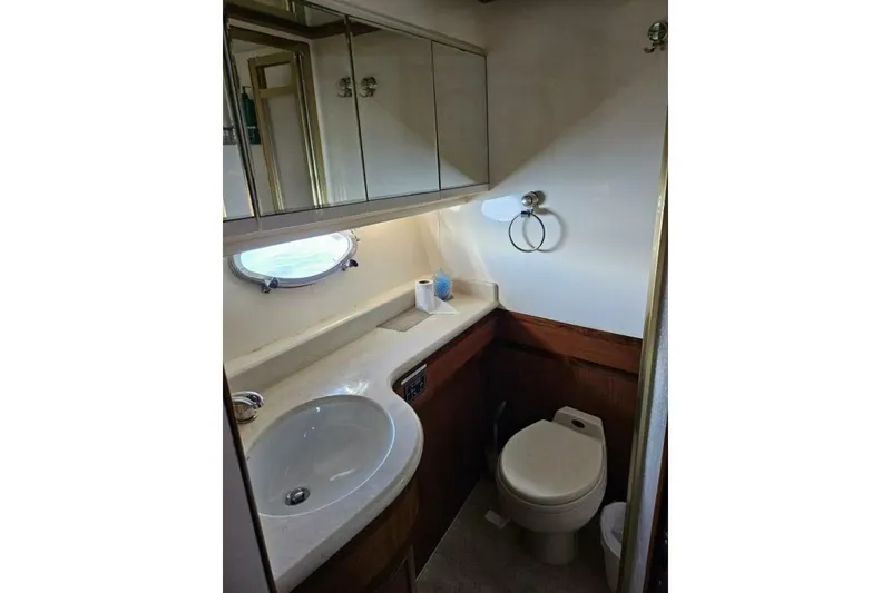 Slide: The Image of Compact bathroom in 2003 Johnson FLY boat with sink, toilet, and mirrored cabinets. - 23