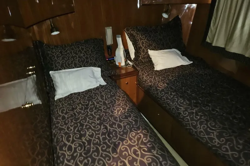 Slide: The Image of Twin beds in a 2003 Johnson FLY yacht cabin with patterned bedding. - 24