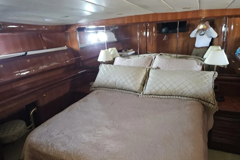 Slide: The Image of Luxurious bedroom interior on 2003 Johnson FLY yacht with elegant wood paneling and plush bedding. - 26