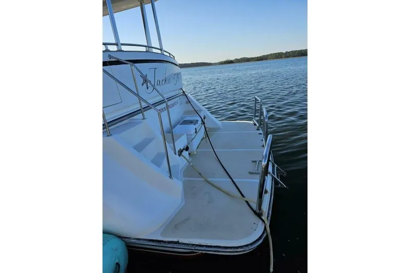 Slide: The Image of 2003 Johnson FLY boat docked on calm water, rear view with steps and railing. - 3