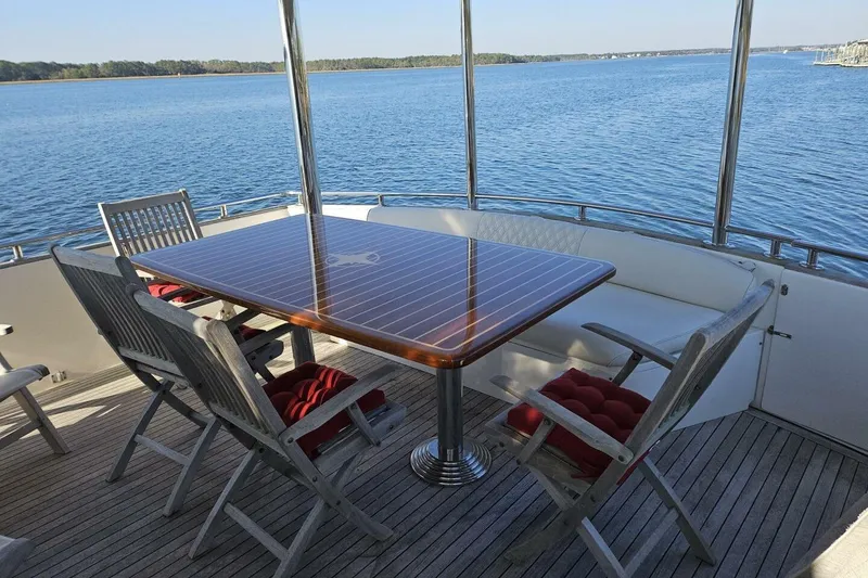 Slide: The Image of Outdoor dining area on 2003 Johnson FLY yacht with scenic water view. - 5