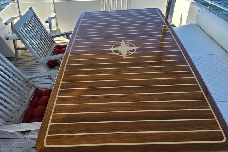 Slide: The Image of Elegant wooden table with compass design on a 2003 Johnson FLY yacht deck. - 6