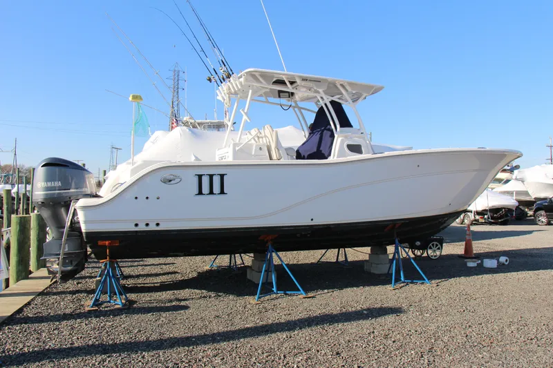The Image of 2020 Sea Fox 328 Commander boat on stands, featuring Yamaha engines, in a marina setting. - 1