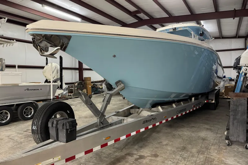 The Image of 2019 Fountain 38 Center Console boat on trailer in indoor storage facility. - 1