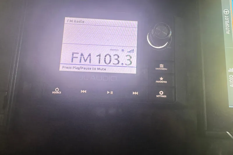 Slide: The Image of Boat audio system displaying FM 103.3 on a 2019 Fountain 38 Center Console. - 23
