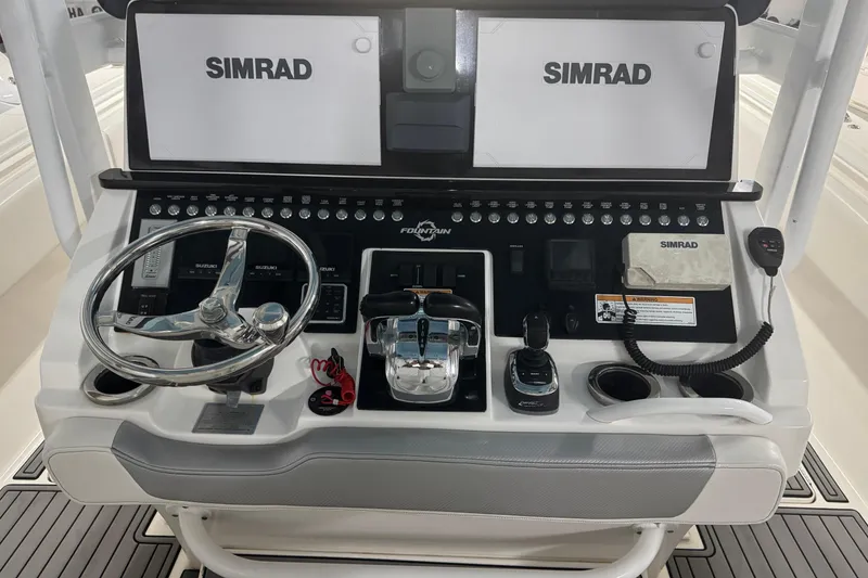 Slide: The Image of 2019 Fountain 38 Center Console boat dashboard with Simrad displays and controls. - 37