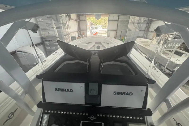Slide: The Image of 2019 Fountain 38 Center Console boat dashboard with Simrad navigation system in a garage. - 38