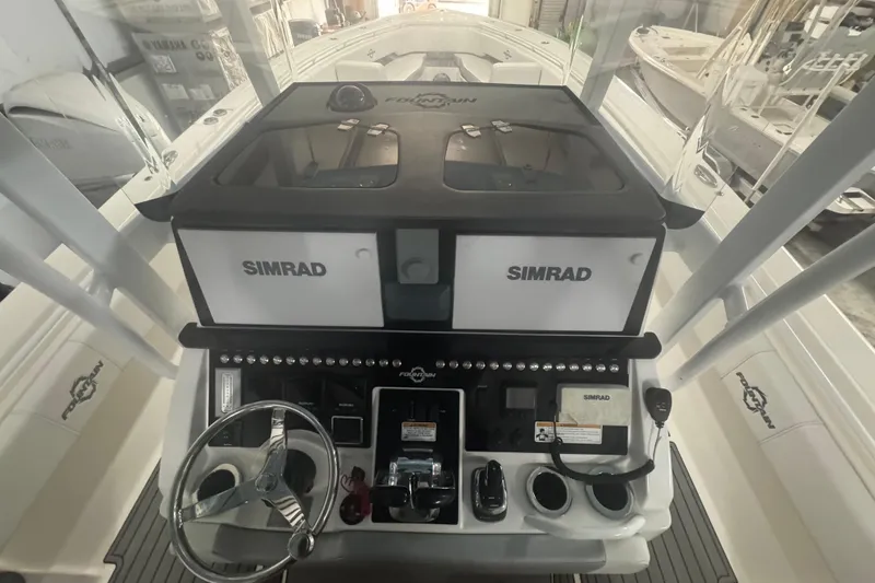 Slide: The Image of 2019 Fountain 38 Center Console boat dashboard with Simrad electronics and steering wheel. - 40