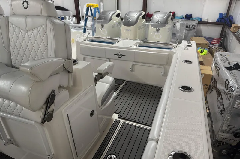 Slide: The Image of 2019 Fountain 38 Center Console boat interior with luxurious seating and triple Suzuki engines. - 53