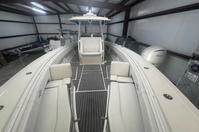 Slide: The Image of 2019 Fountain 38 Center Console boat interior with seating and Yamaha engines in a storage facility. - 7