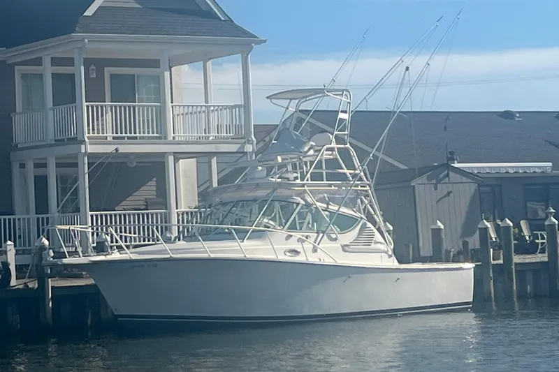 The Image of 2008 Henriques 30 Express boat docked beside a waterfront house. - 1